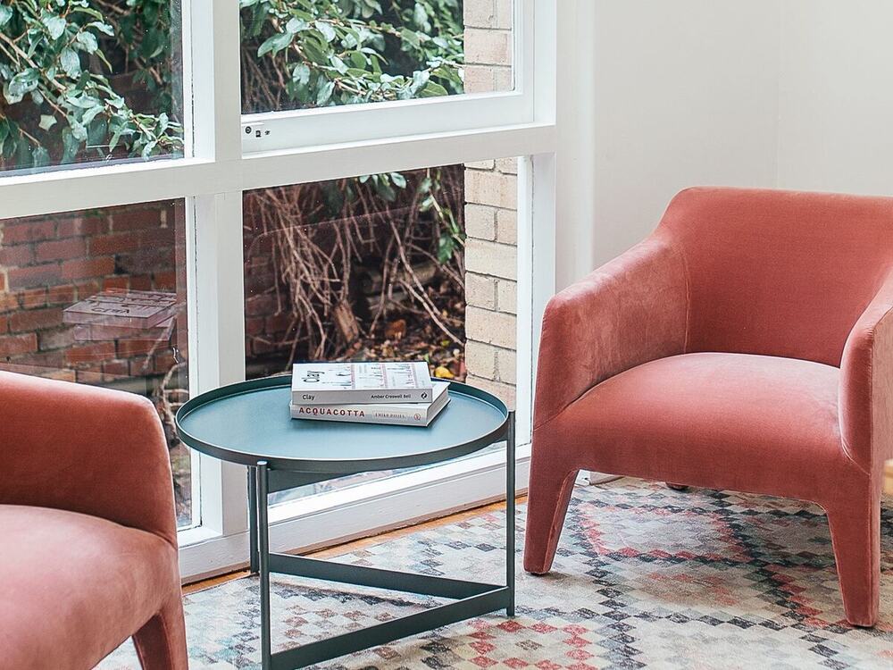 Two armchairs and a side table in a light consulting room