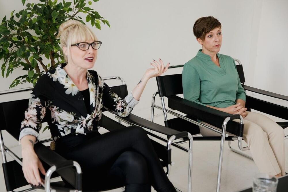 Two practitioners sitting in chairs facing each other during a supervision session