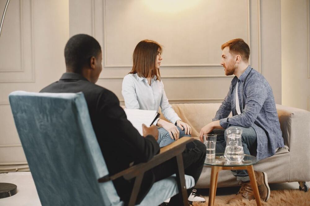 Two parents talking with a practitioner in a private session